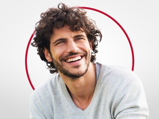 Smiling young man in a grey jumper, happy after Canesten thrush treatment